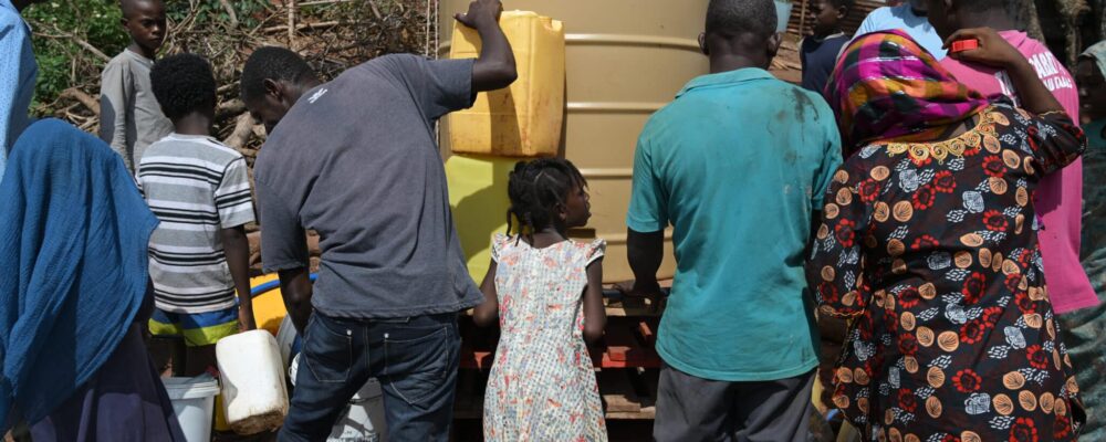 Les habitants du bidonville viennent remplir leurs bidons avec l’eau potable ramenée par la Croix Rouge. Les premiers sont arrivés tôt le matin plusieurs heures avant l’arrivée du camion.