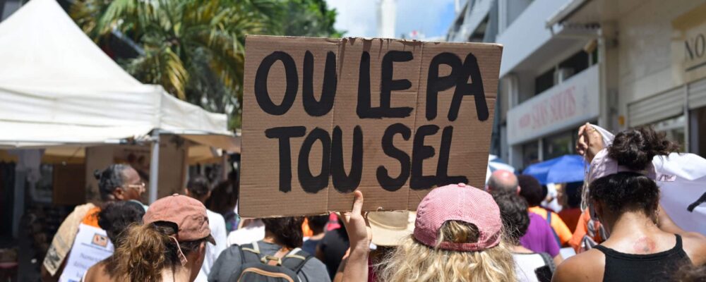 Une manifestante tient une pancarte sur laquelle on peut lire 